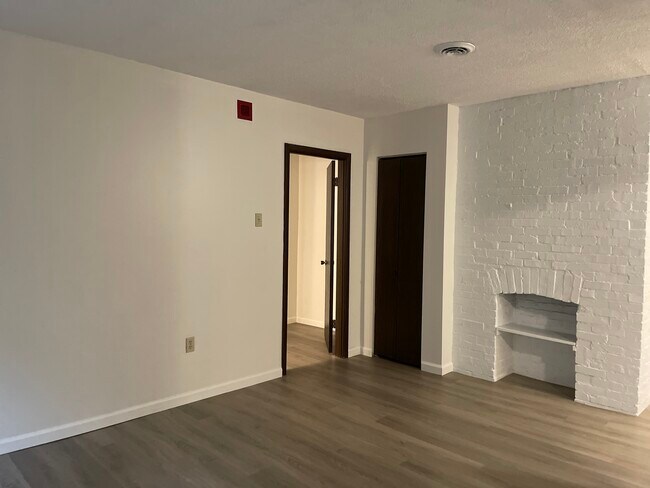 Living room has decorative fireplace, utility closet, entrance to bedroom - 5523 Ellsworth Ave