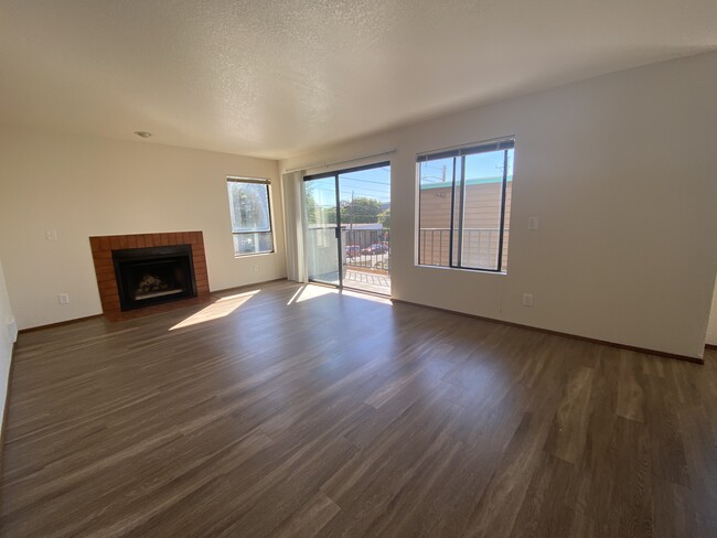 Open living room has wood burning fireplace - Mona Lisa Apartments