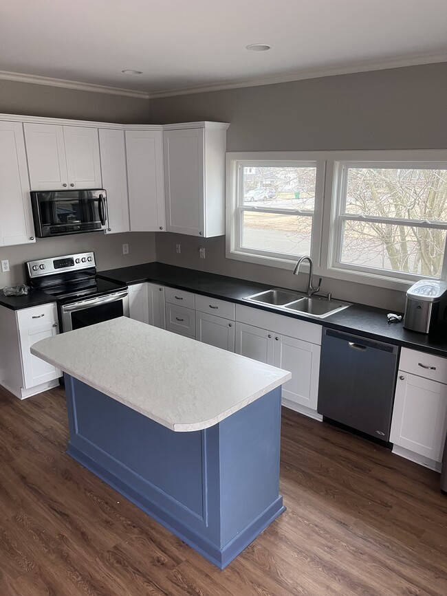 Beautiful kitchen with island stove, and microwave - 701 E 4th St