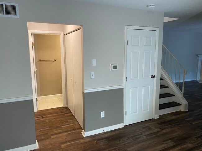 Dining Room with 1/2 bath at end of hallway, storage closets, basement door and stairs upstairs - 8555 Island Pines Dr