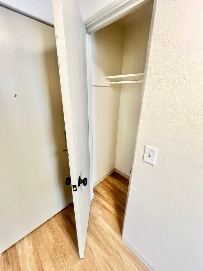 Explore the generous storage options with this sleek and well-designed closet. - Harmony Apartments