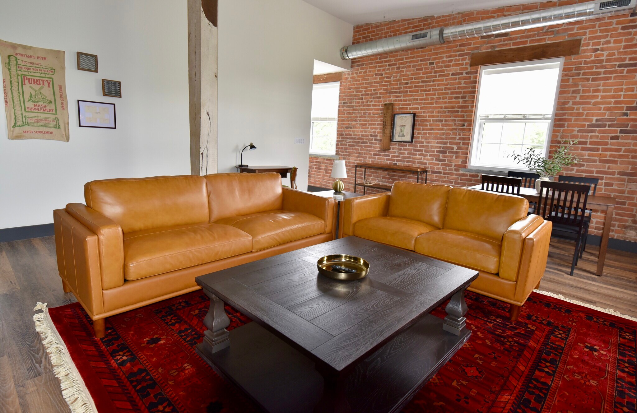 Furnished living room features leather couches, dining table and coffee tables - 101 W Broadway St