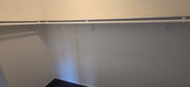 Walk-in closet with wrap around shelving and hanger rods - 14365 Foothill Blvd