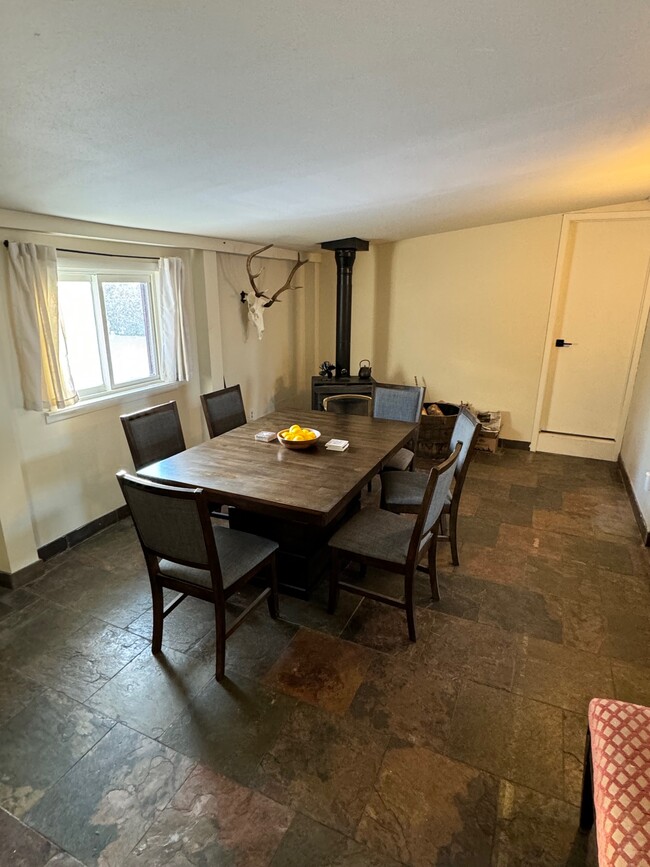 Dining room with wood stove. Storage through door behind. - 92 E Rosebud Ave