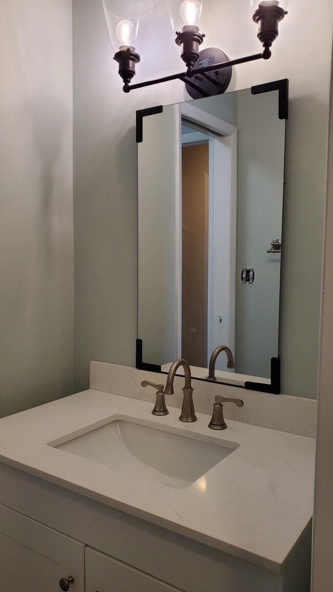 Bathroom vanity with new mirror and light fixture - 1675 Cedarwood Dr