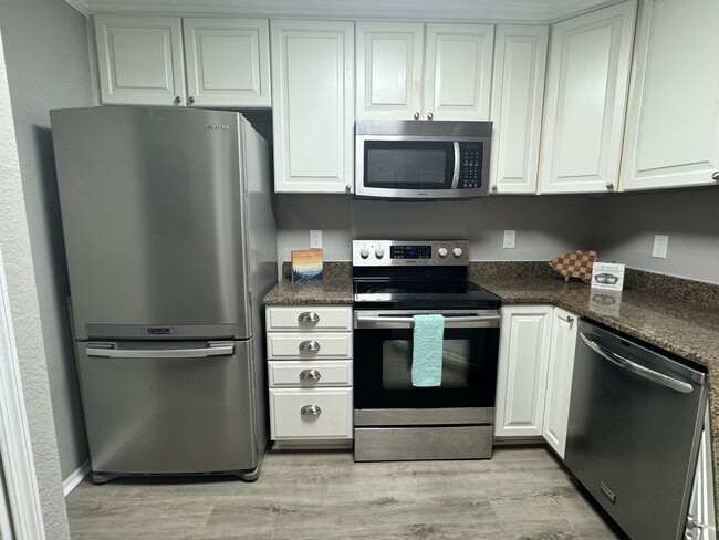 Beautiful white kitchen with crown molding and ceiling height upper cabinets and stainless appliance - 3705 SW 27th St