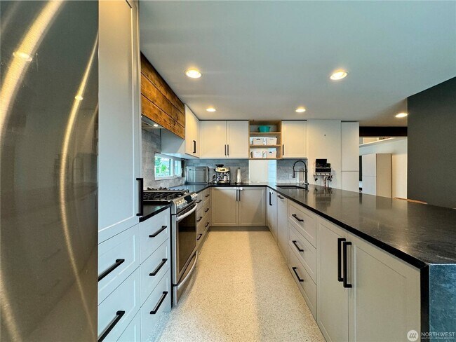 Building Photo - Remodeled 3 bdrm home on a large lot with 500 sq ft wrap around deck!