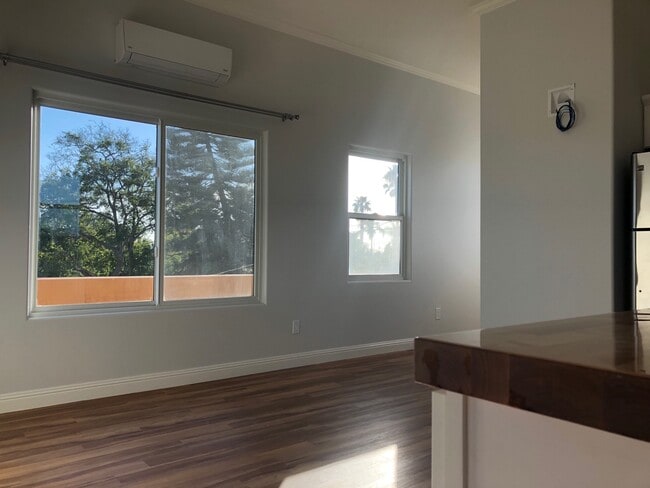Picture windows from open floor plan living room. A/C unit is centrally located high on the wall. - 4470 Swift Ave