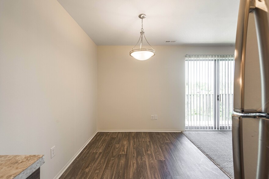 Spacious dining room with natural light and hardwood floors at Knottingham Apartments in Clinton Township, MI - Knottingham Apartments
