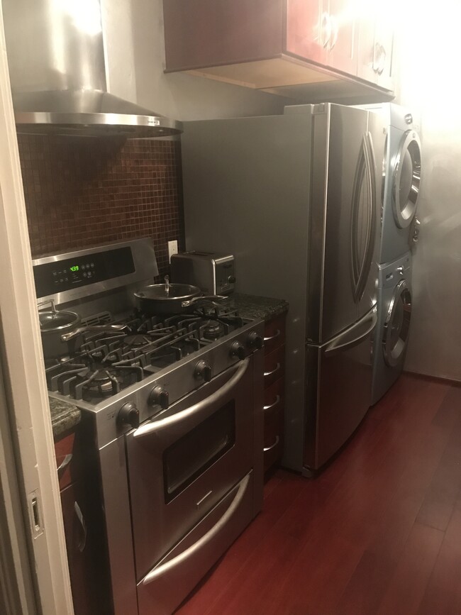 Five burner stainless steel chef stove, with stainless steel refrigerator, washer and dryer at the e - 1857 Pandora Ave