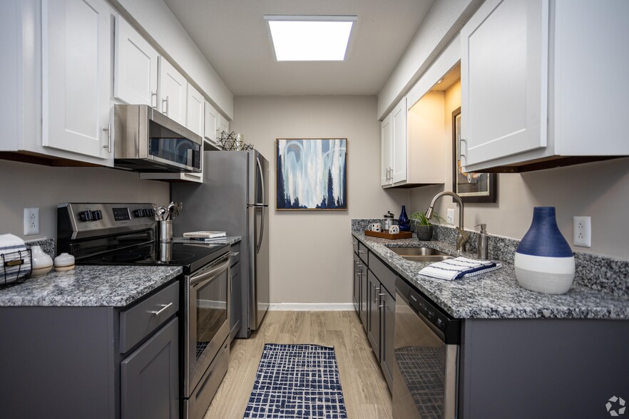 Kitchen with granite counters, stainless appliances, and modern cabinetry - Addison at Sutherland