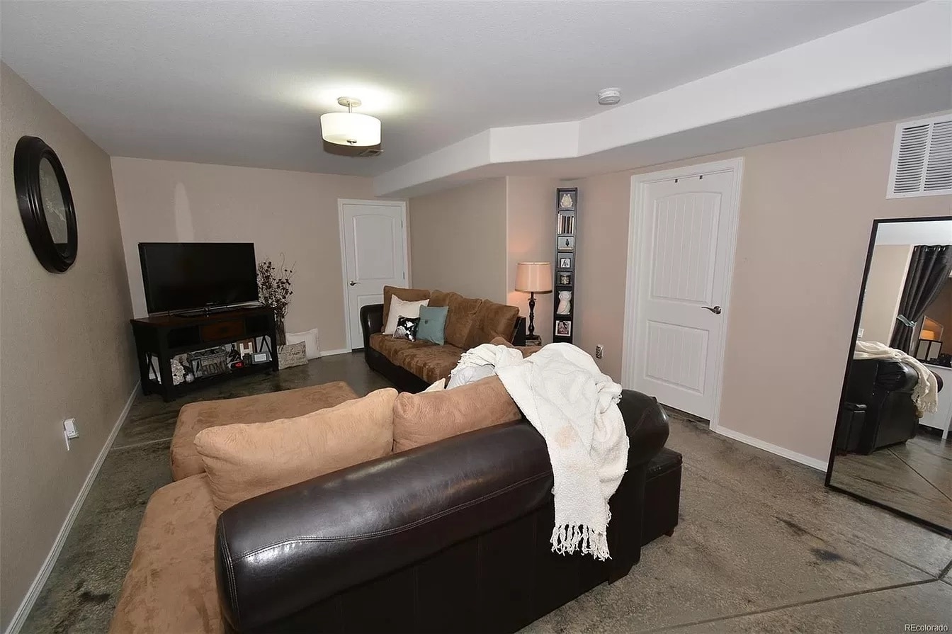 Second basement living room with acid stained concrete floors throughout the basement - 8782 Windy Plains Ct