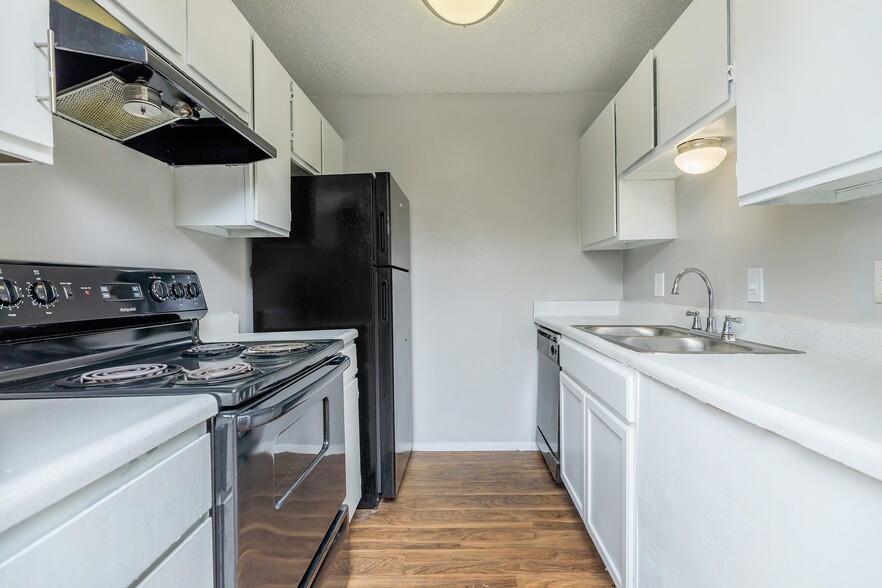 Discover a beautifully updated kitchen featuring bright cabinetry, sleek countertops, and modern black appliances. With ample storage and a functional layout, this space is designed for both style and efficiency. - Casa Del Sol