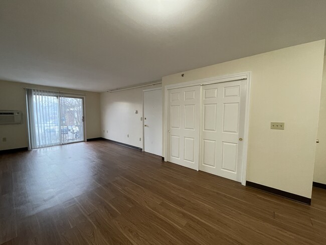 Living room with A/C unit - Highland Estates Apartments