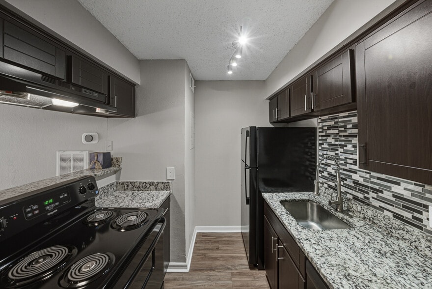 Modern apartment kitchen with updated finishes and appliances - Magnolia Apartments
