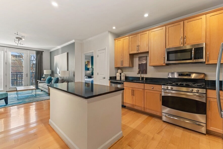 Gourmet kitchens with 42" wood cabinets and granite countertops - The Reserve at Tysons Corner