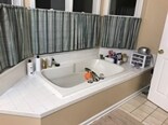 Soaking tub, bay window, shower, and double vanity are highlights of master bath - 1809 Stark Drive