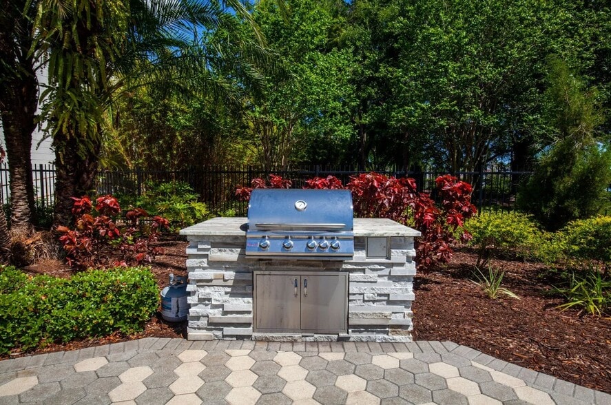 Elevate your living experience at The Grove at Temple Terrace Apartments, where outdoor gatherings are made easy with our state-of-the-art grilling station amidst lush landscaping. Join us today and make your culinary moments unforgettable! - The Grove at Temple Terrace Apartments