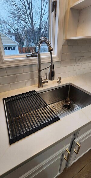 Featuring a modern deep stainless-steel undermount sink with integrated drying rack and cutting boar - 90 E 216th St