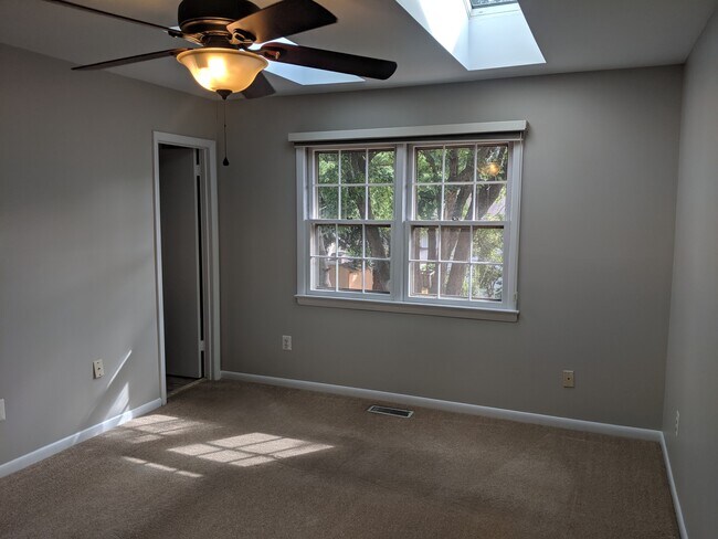 Master bedroom with large windows, skylights, and ceiling fan - 46675 Winchester Dr