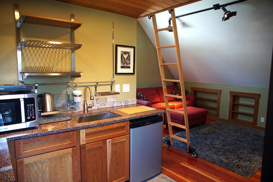 Part of kitchenette shelving installed, studio lighting, full-size fridge by entrance replaced mini - 69 S Shannon Ave