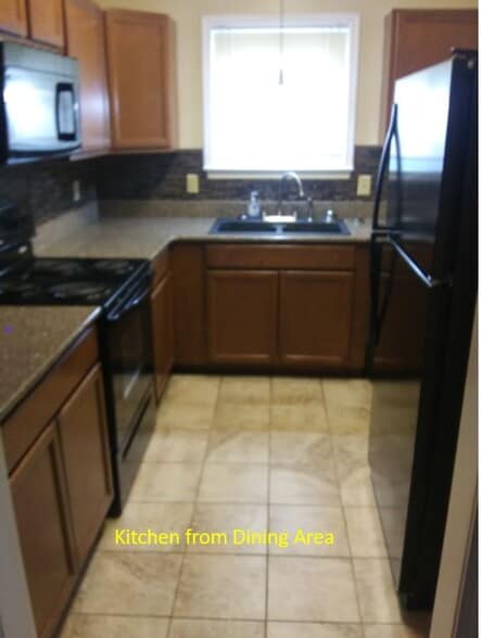 Kitchen from dining room. - 7933 Bles Ave