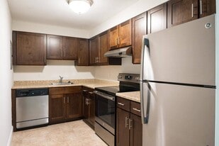 Classic kitchen style with rich cabinetry and neutral countertops, offering a warm, timeless aesthetic. - Stone Run East