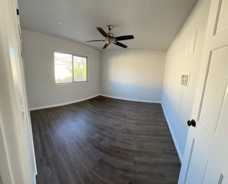 Bedroom with custom window coverings and newly installed plank flooring. - 1016 Western Ave