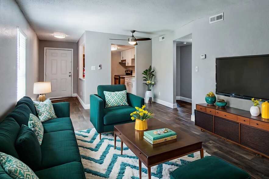 Inviting living room with elegant teal furnishings, a modern patterned rug, and warm natural light creating a cozy ambiance. - Heritage Cove