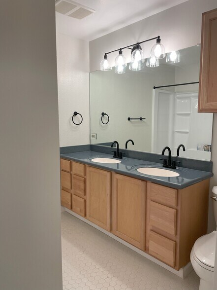 Main bathroom. Double sinks, large walk-in shower, and toilet - 8717 NE Webster St