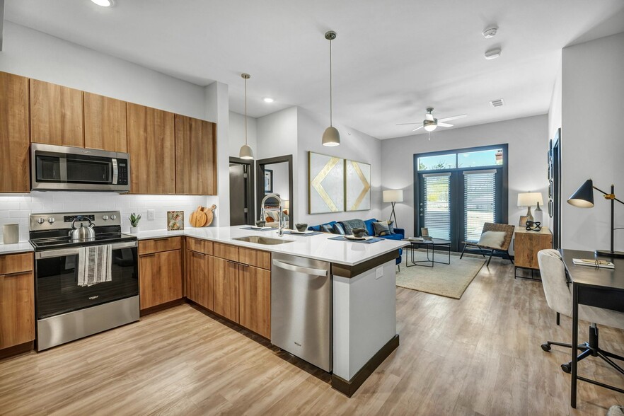 Greeted by the large kitchen and living room as you enter - The Brick and Mortar District Apartments