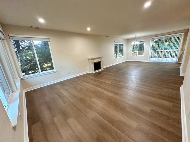 Spacious living room with lots of lights with brand new vinyl flooring and wooden blinds. - 17731 NE 88th Pl