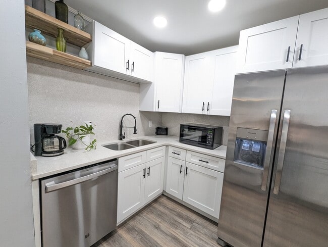 The kitchen has been recently renovated with modern amenities, stainless appliances, a dishwasher, l - 4107 Crane St