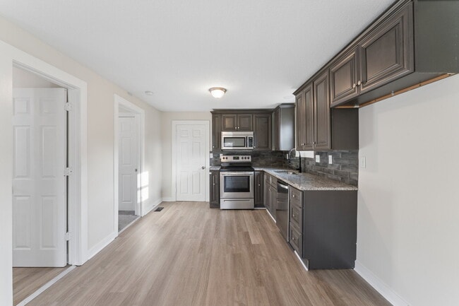 Building Photo - This cozy residence features a bright living space and well-appointed kitchen.  1st month is FREE...