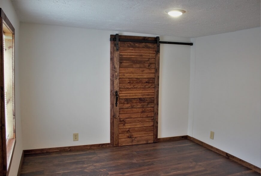 Downstairs bedroom with sliding barn door to walk-in closet. One window, newer flooring, newer paint, newer light fixture, new wiring. - 9331C Tallmadge Road