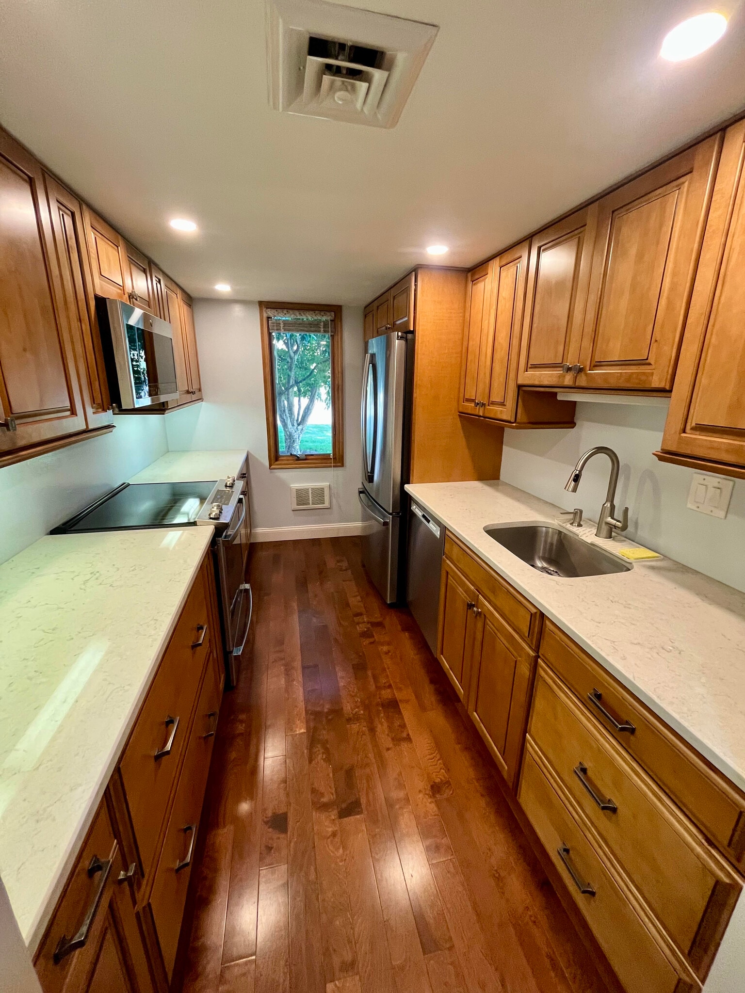 Kitchen with modern appliances, and view of trees and grass - 77 Windward Ln