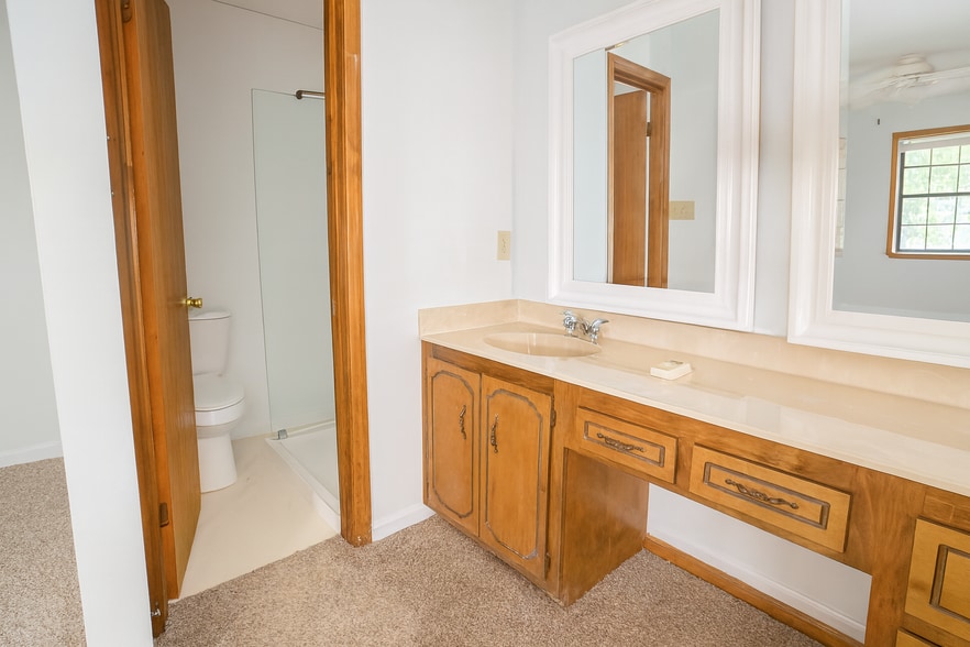 Master bath with dual mirrors, wood vanity, and private walk-in shower for comfort. - 2313 Salem West Dr