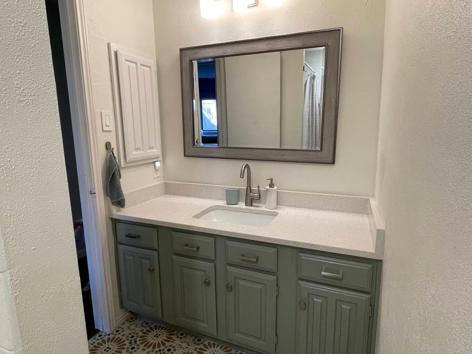 Double vanity with large mirror and modern fixtures in the primary bathroom. - 2401 Thistle Ct