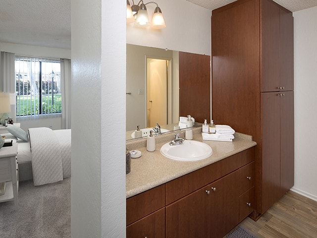 Classic Package II bath with dark cherry cabinetry, beige laminate countertop, and hard surface flooring - eaves South Coast