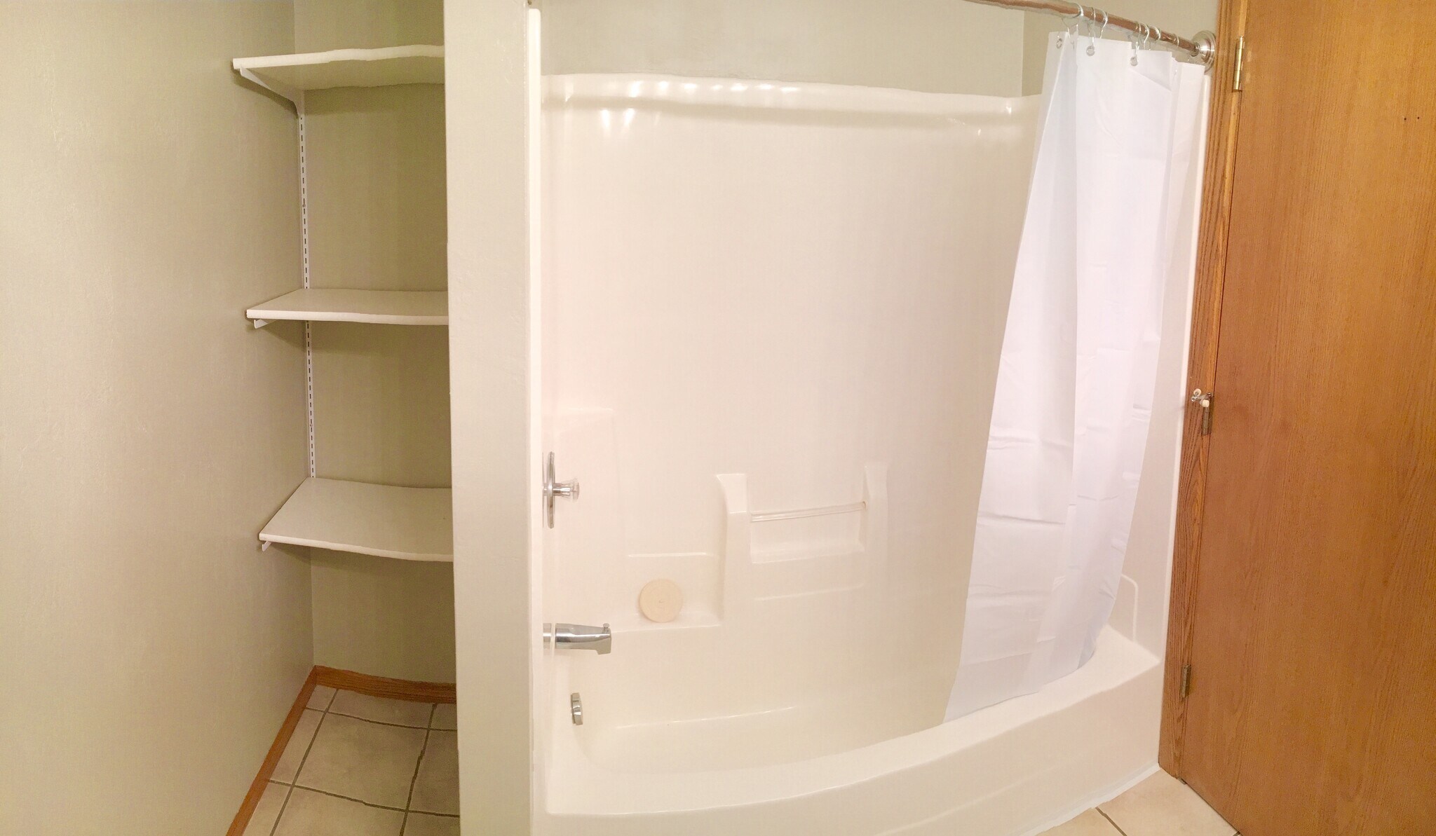 Main Bathroom with storage shelves and one piece tub/shower surround. - 325 Cordy Lane