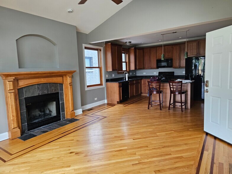 Living room has a wood burning fireplace -- rare in Chicago. Adjacent kitchen. - 4933 N Winthrop Ave