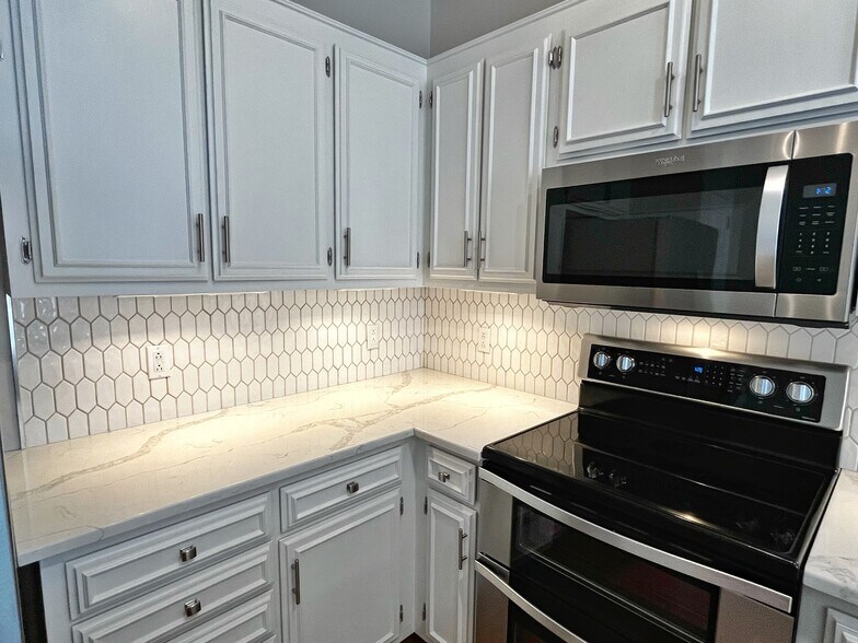 Upgraded kitchen includes quartz countertops, undercabinet lighting, and stainless appliances. - 604 Sherbourne Grn