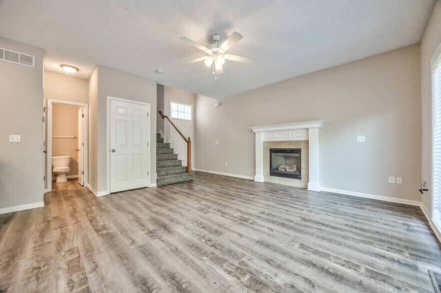 Living room with fireplace and ceiling fan - 22810 West 71st Terrace