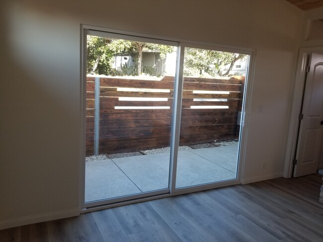 Master bedroom with wood high ceilings, ceiling fan, private courtyard, custom driftwood mantel over - 6832 Zelzah Ave