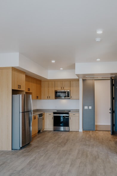 clean modern kitchen with custom cabinetry - The Cue Apartments