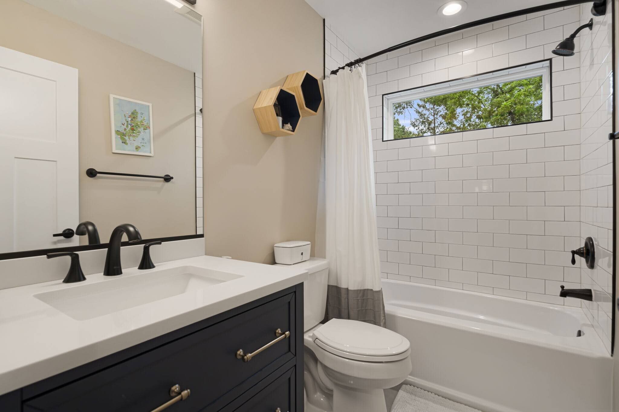 Shared secondary bathroom on top floor with modern white subway tile filled with natural light. - 33 Rex Dr