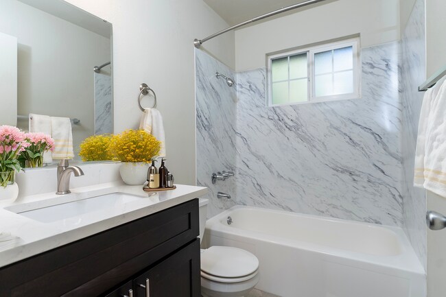 Experience luxury with this tastefully designed bathroom, featuring elegant marble and charming decor. - University Crossing Apartments