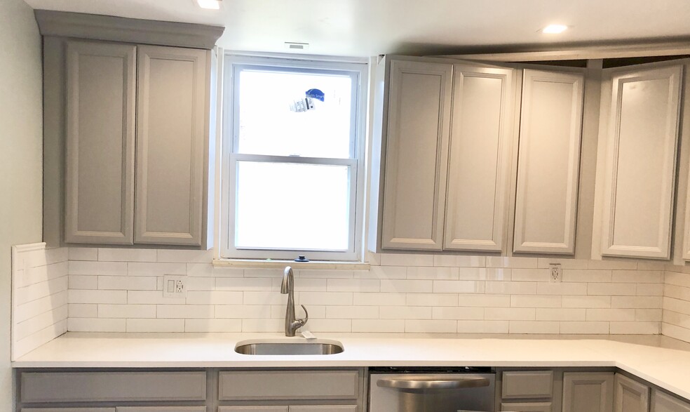 Light and bright kitchen with quartz countertops, dishwasher, gas range stove, huge refrigerator, and microwave - 307 Fisk St