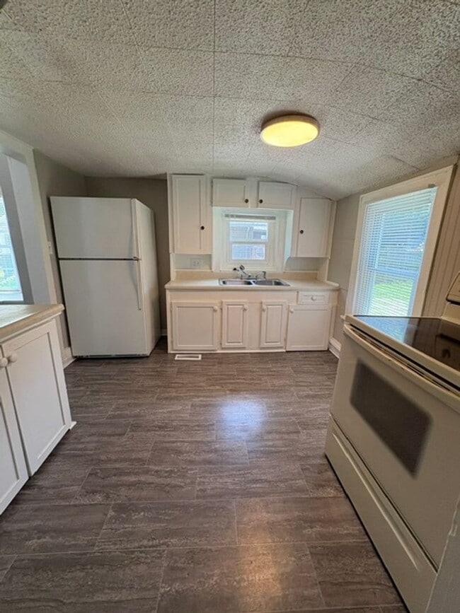 Building Photo - A cozy 2 bedroom home with versatile living space and plenty of storage including a partially fin...