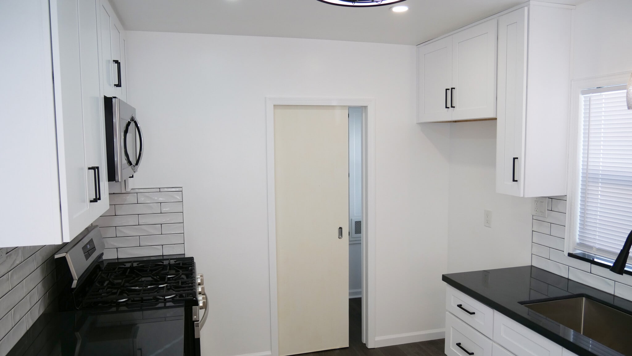 Through the kitchen to the laundry room. Beautiful modern look. Pocket door for privacy. - 259 E Puente St